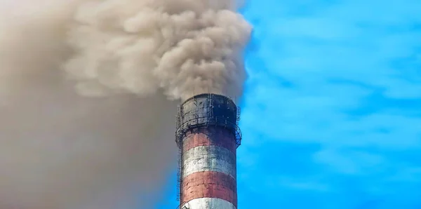 Kouřící trubka dělí modrou oblohu na dvě části. — Stock fotografie