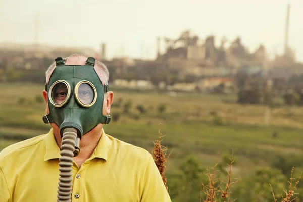 Man in gas mask. View of the industrial factory. Toned image. — Stockfoto