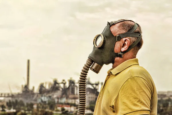 Person med gasmask. Utsikt över industrifabriken. — Stockfoto
