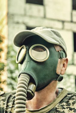 Gaz maskesi ve kap closeup tahrip kentsel arka plan erkekler. 