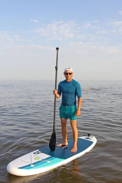 晴れた日に男は夏の海のSupボードで訓練しています パドルボードサーフィン — ストック写真