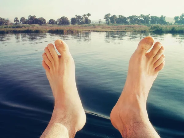 ナイル川を背景に裸の足が近づいてきた 旅行のコンセプト ストックフォト
