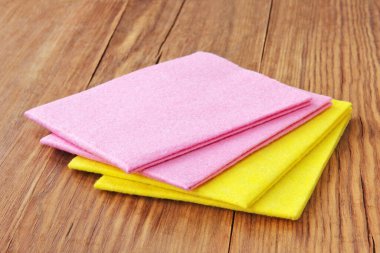Ev kavramı. Ahşap zemin üzerinde çok renkli mikro fiber peçeteler.