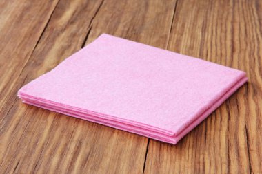 Ev kavramı. Ahşap arka planda pembe mikro fiber peçeteler yakın plan çekilmiş..
