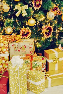 Noel ağacı ve Noel süslemeleri yakınındaki Noel hediye kutuları.