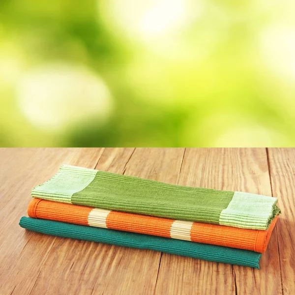 Pile Various Folded Placemats Kitchenclothe Wooden Table Defocused Green Background — Stock Photo, Image