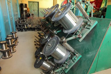 Esnek metal hortum üretim hattı. Örgü makinesi. Çelik tel makaraları..