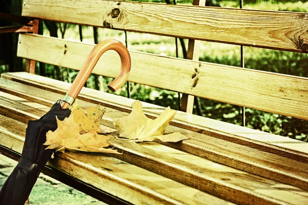 木製の公園のベンチに黒い傘が閉じられました — ストック写真