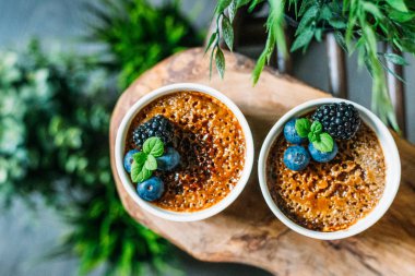 Yeşil Bitkiler A ile Koyu Arka Plan Üzerinde Çilek ile Creme Brulee