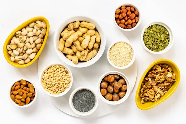 Various Nuts and Seeds on White Background in the Bowls - Image — Stock Photo, Image