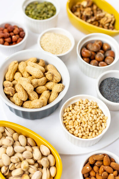 Various Nuts and Seeds on White Background in the Bowls - Image