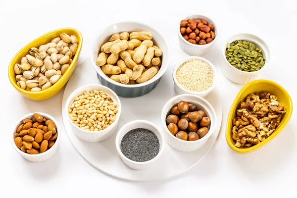 Various Nuts and Seeds on White Background in the Bowls - Image — Stock Photo, Image