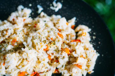 Ev yapımı soğanlı tavuk risotto ve Dark Backgroun 'da havuç.