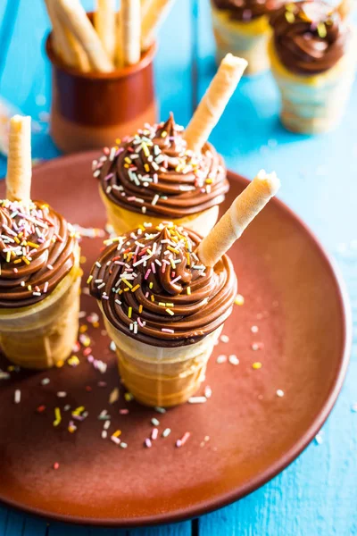 Cupcakes de chocolate de baunilha na taça de waffle em fundo azul — Fotografia de Stock