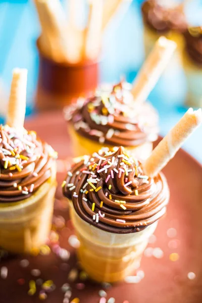 Pasteles de chocolate con vainilla en taza de gofres sobre fondo azul —  Fotos de Stock