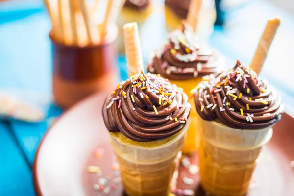 Cupcakes de chocolate de baunilha na taça de waffle em fundo azul — Fotografia de Stock