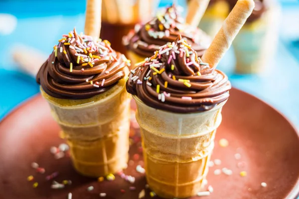 Pasteles de chocolate con vainilla en taza de gofres sobre fondo azul — Foto de Stock