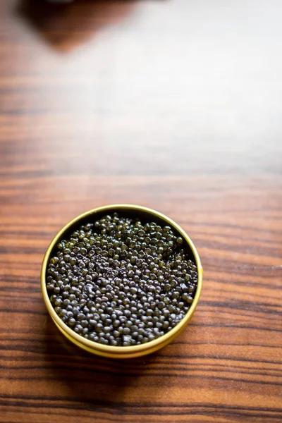 A Jar with Black Caviar on the Wooden Background Royalty Free Stock Images