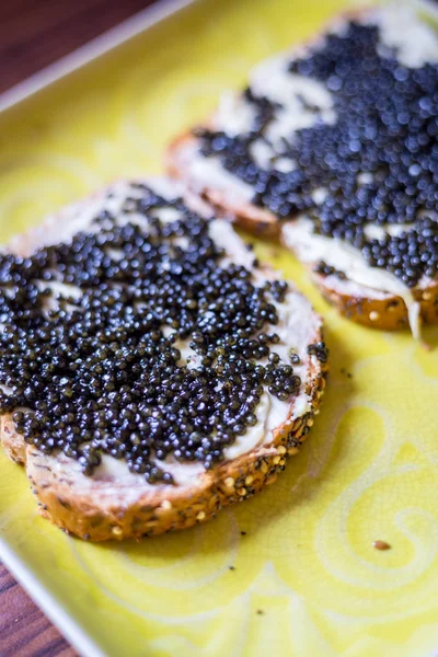 Sandwiches with Black Caviar on the Yellow Rustic Plate, Top Vie Ліцензійні Стокові Фото