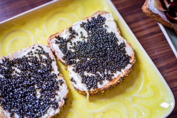 Sandwiches with Black Caviar on the Yellow Rustic Plate, Top Vie Royalty Free Stock Images