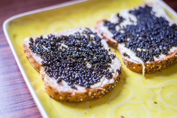 Sandwiches with Black Caviar on the Yellow Rustic Plate, Top Vie Стокова Картинка