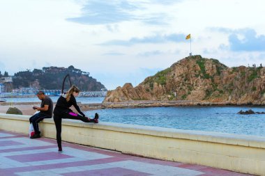 Sporcu kız kıyısındaki ısınıyor. Blanes İspanya