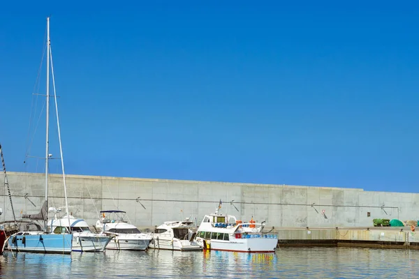 Plachetnice, motorové lodě zakotvené seawall. Blanes, Španělsko — Stock fotografie