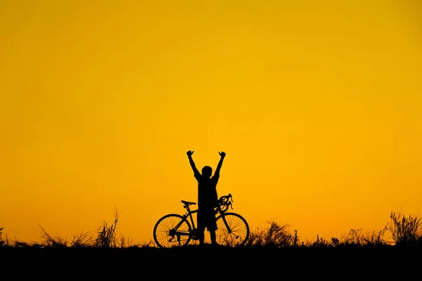 Silhouette of cyclist with friend in motion on the background of beautiful sunset.