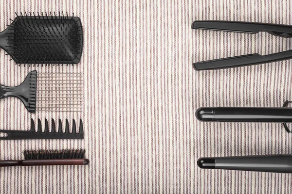 Hair straightening tools lying opposite to combs — Stock Photo, Image