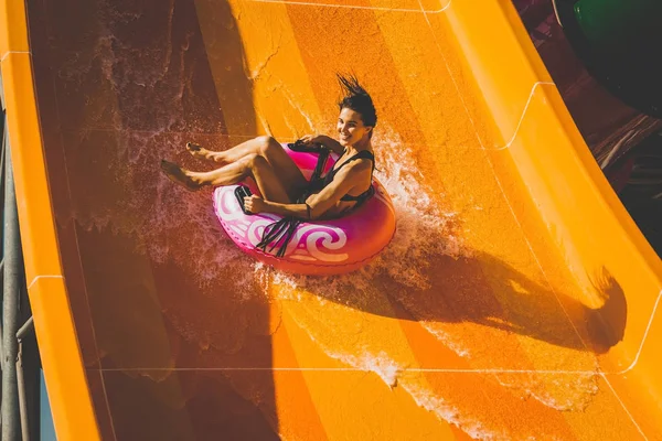 Mulher se divertindo descendo na corrediça de água — Fotografia de Stock