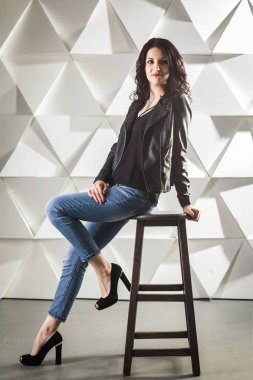 esmer kız yüksek tabure stüdyoda oturup...