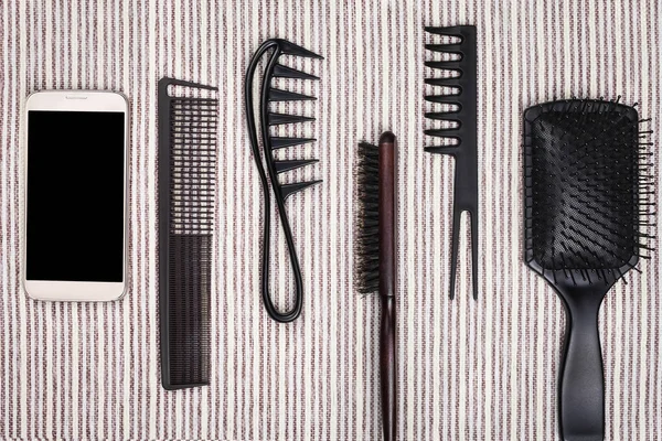 Fonelaying inteligente cerca de muchos cepillos para el cabello — Foto de Stock