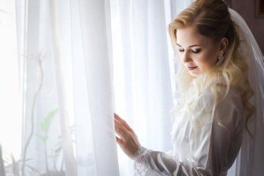 Gelin sabahlığı ayakta pencerenin önünde