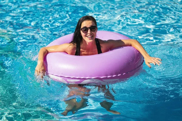 Mulher muito feliz segurando anel de natação na piscina — Fotografia de Stock