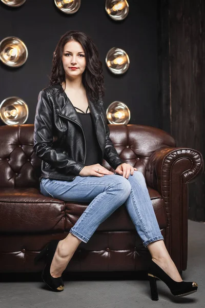 Woman sitting on couch in the studio