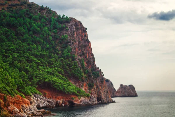 kaya, deniz ve bulutlu gökyüzü
