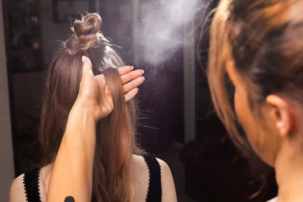 Hairdresser fixing hair of a model with a hairspray — Stock Photo, Image