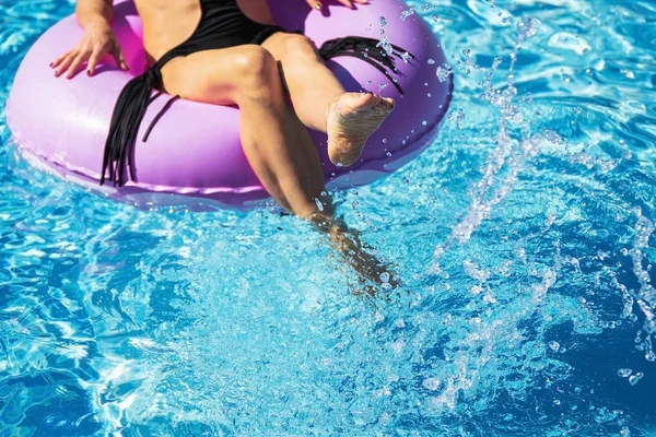 Damenbeine spielen mit Wasser im Becken — Stockfoto