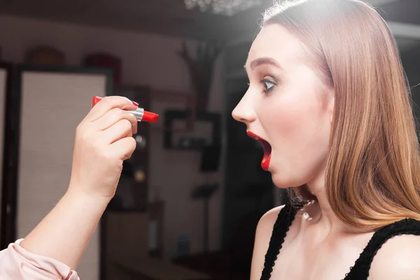 Kırmızı dudak parlatıcısı şok bir model üzerinde koyarak makyaj kadın — Stok fotoğraf