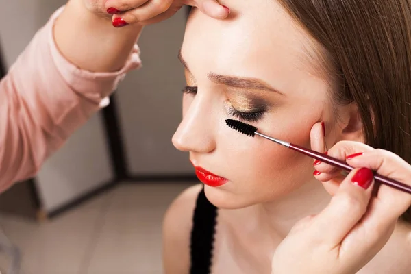Makeup artist applying mascara on a model close up — Stock Photo, Image