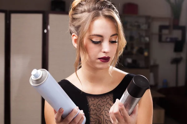 model holding two hair sprays