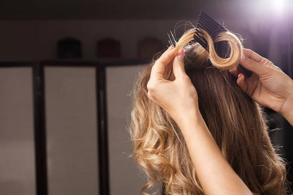 Κομμώτρια που χτενίζει τα μαλλιά μπούκλα Royalty Free Εικόνες Αρχείου