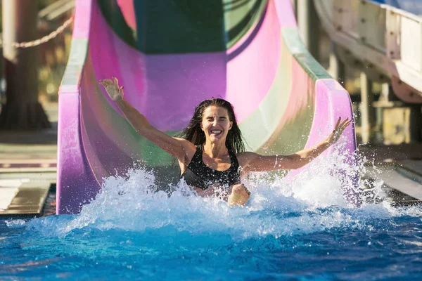 Donna mani diffusione divertirsi sullo scivolo d'acqua — Foto Stock