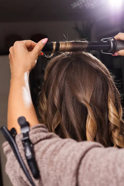 Kampaaja tekee hiukset curling asiakkaalle — kuvapankkivalokuva