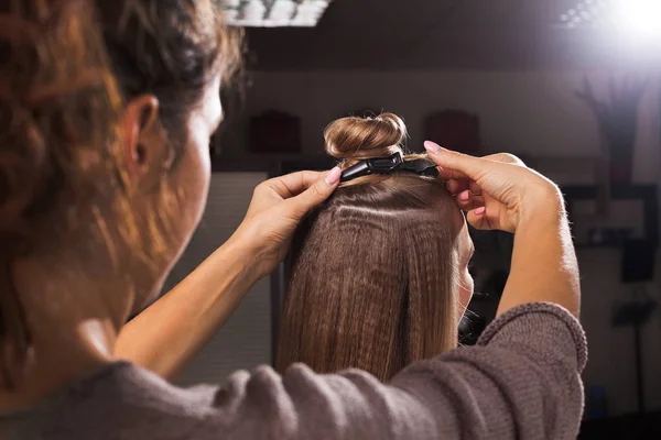 Cabeleireiro cortando um penteado com um nó superior — Fotografia de Stock