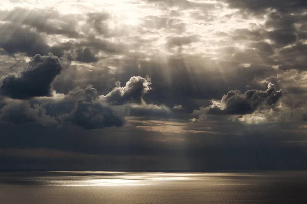 De stralen van de zon krijgen door de lucht op het water — Stockfoto
