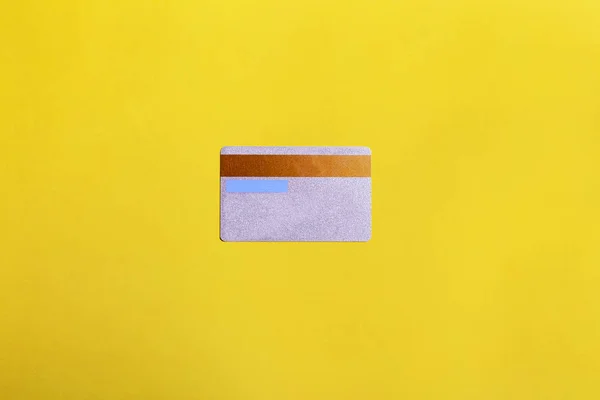 Gold kreditkort isolerad på gul bakgrund — Stockfoto