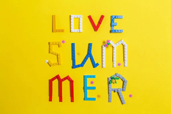 Inscrição amor verão colocado em uma superfície amarela — Fotografia de Stock