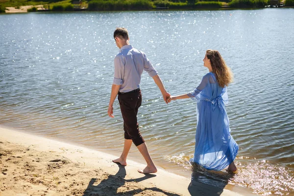 Future parents walking on water along river shore — Stock Photo, Image