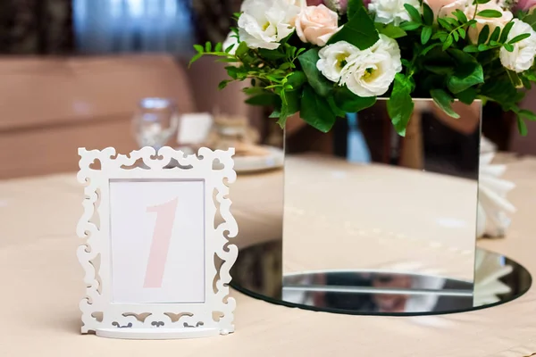 Gerahmte Arrangementnummer in der Nähe der Vase mit Blumen — Stockfoto